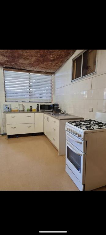 una cucina con un piano cottura e un forno in una stanza di Desert Gum Grund st a Coober Pedy