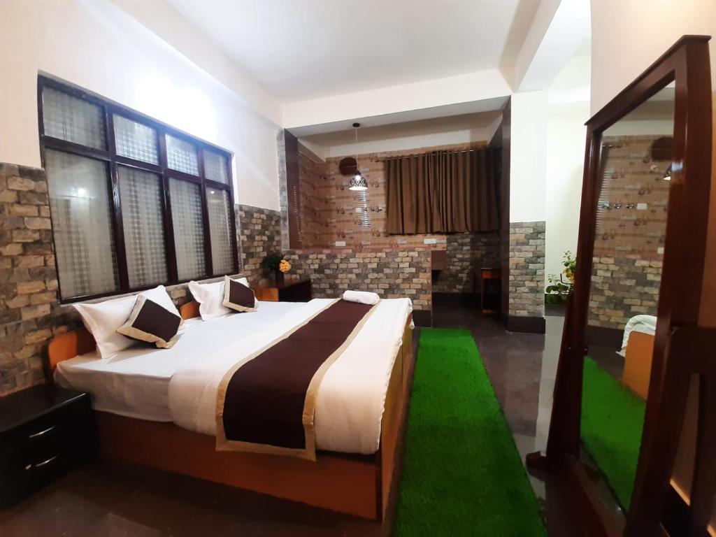sypialnia z dużym łóżkiem i lustrem w obiekcie Dzomo Homestay w mieście Gangtok