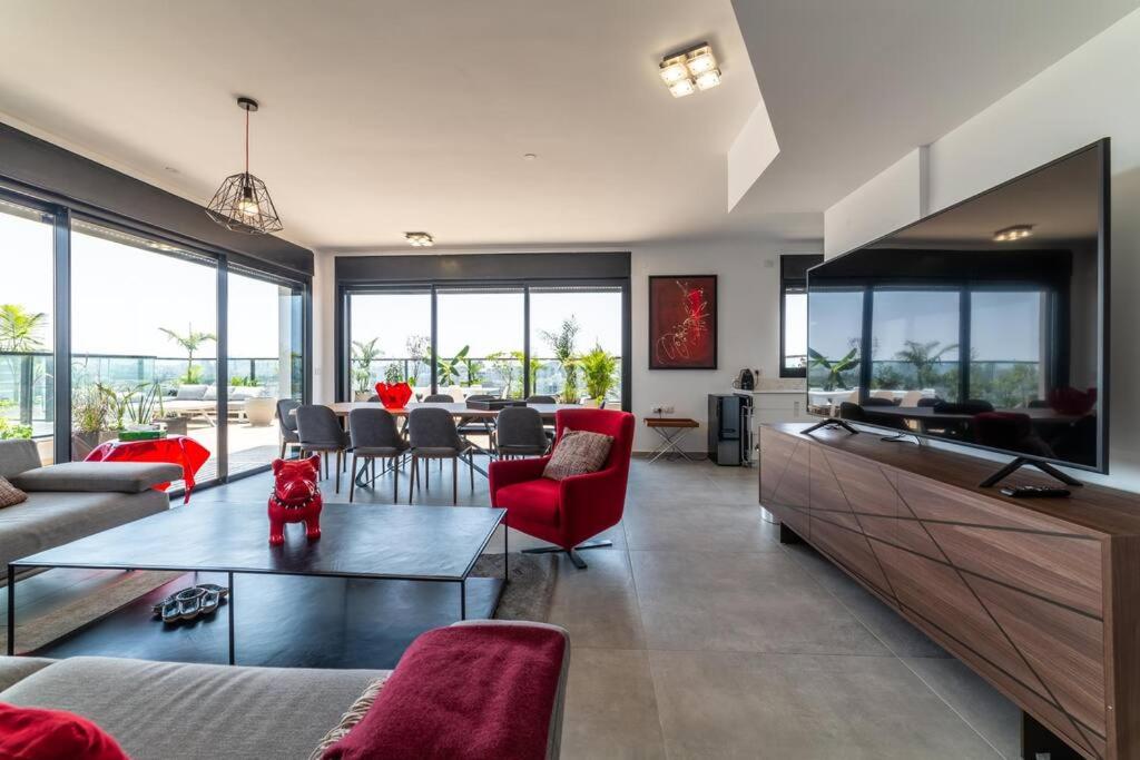 a living room with red chairs and a table at Bautiful Penthouse 4Bed with Jacuzzi sea view in Tel Aviv