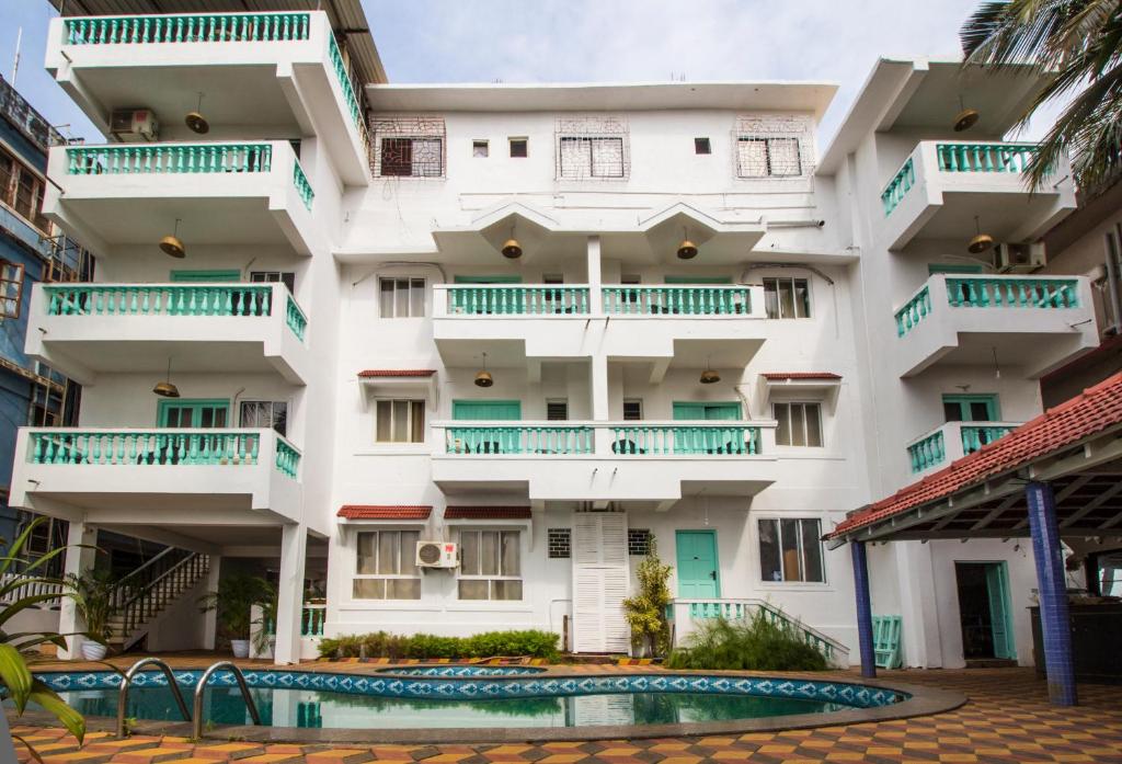 um edifício de apartamentos com uma piscina em frente em TTH em Goa Velha