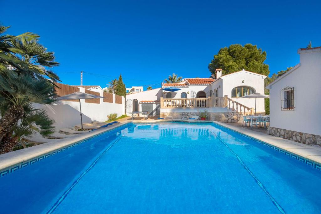 a swimming pool in front of a villa at Casa Virginia in Jávea