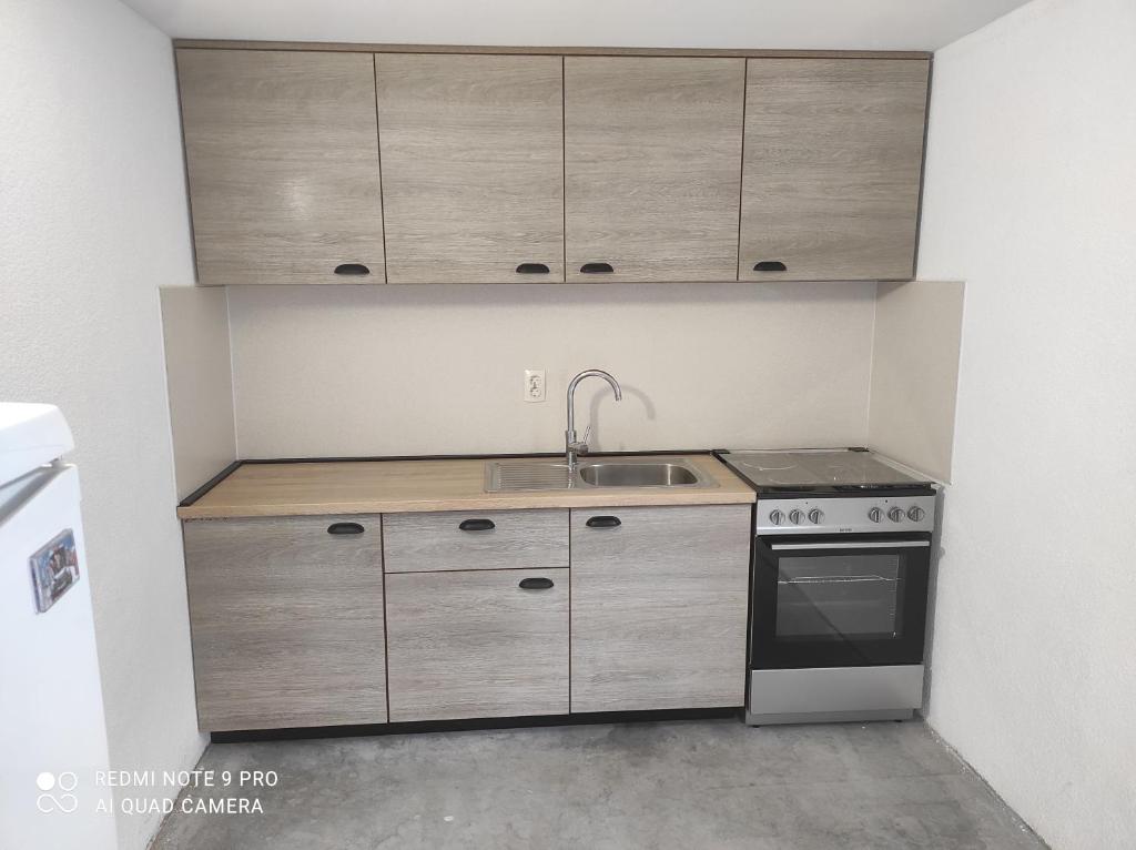 a kitchen with a sink and a stove and cabinets at Marco Polo in Novi Travnik