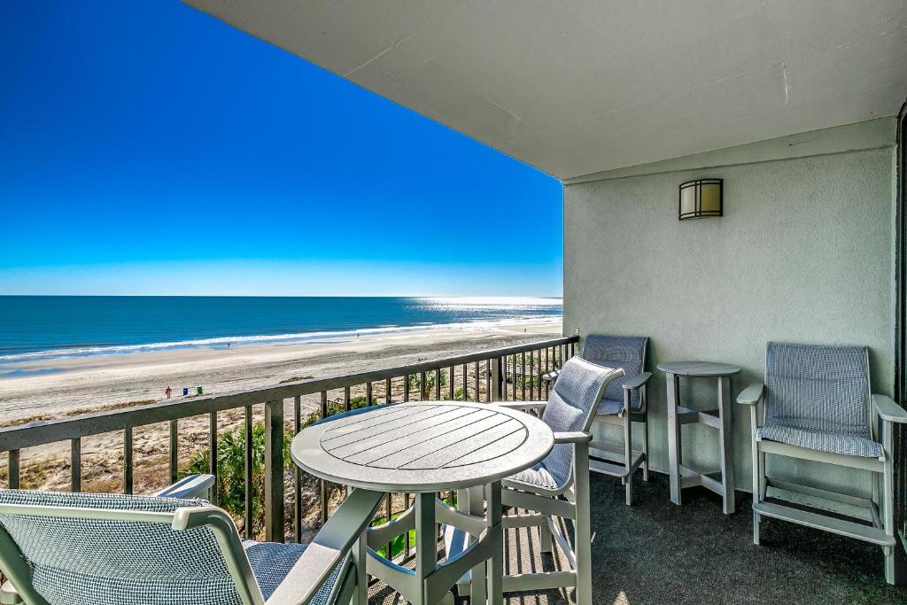 balkon z krzesłami i stołem oraz plaża w obiekcie Carolina Dunes - 401 w mieście Myrtle Beach