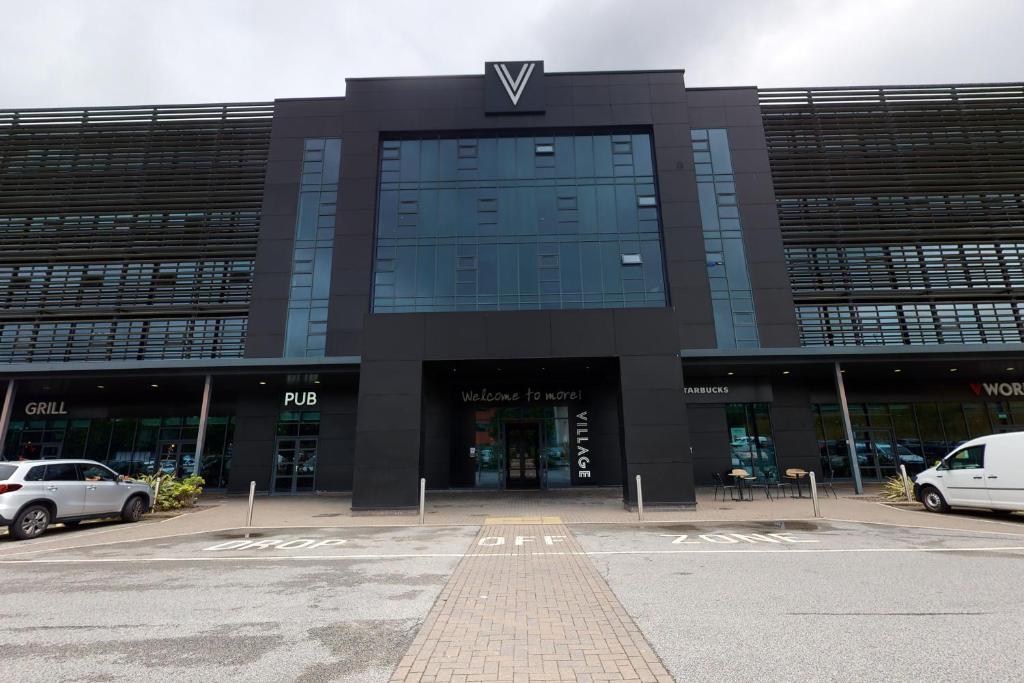 un parking en face d'un bâtiment dans l'établissement Village Hotel Leeds South, à Leeds