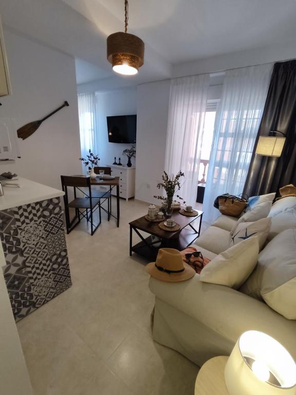 a living room with a couch and a table at APARTAMENTO FRENTE AL MAR CON PRECIOSAS VISTAS in Mazagón