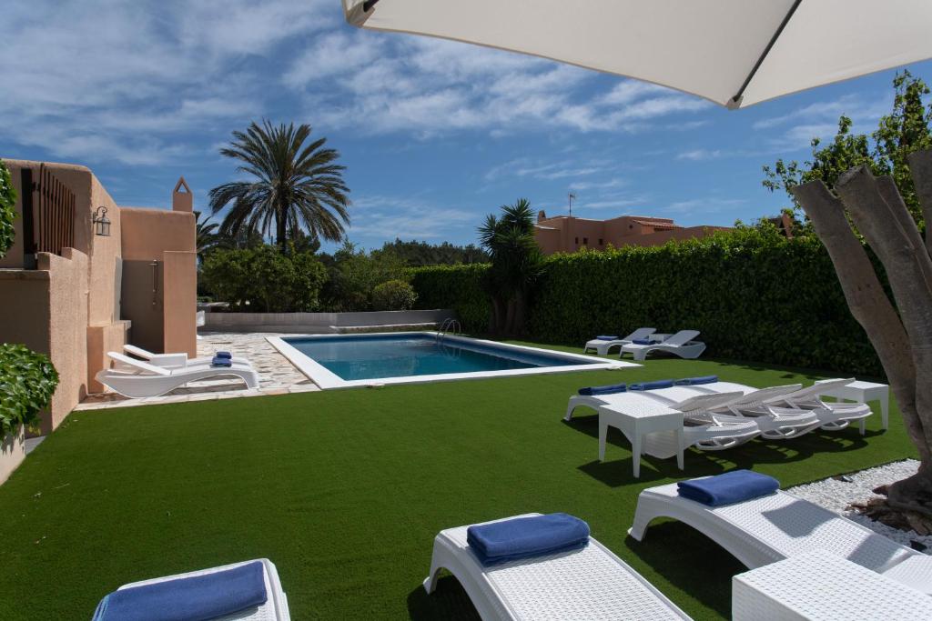 a backyard with a swimming pool and lawnitures at Villa Simona Ibiza in Ibiza Town