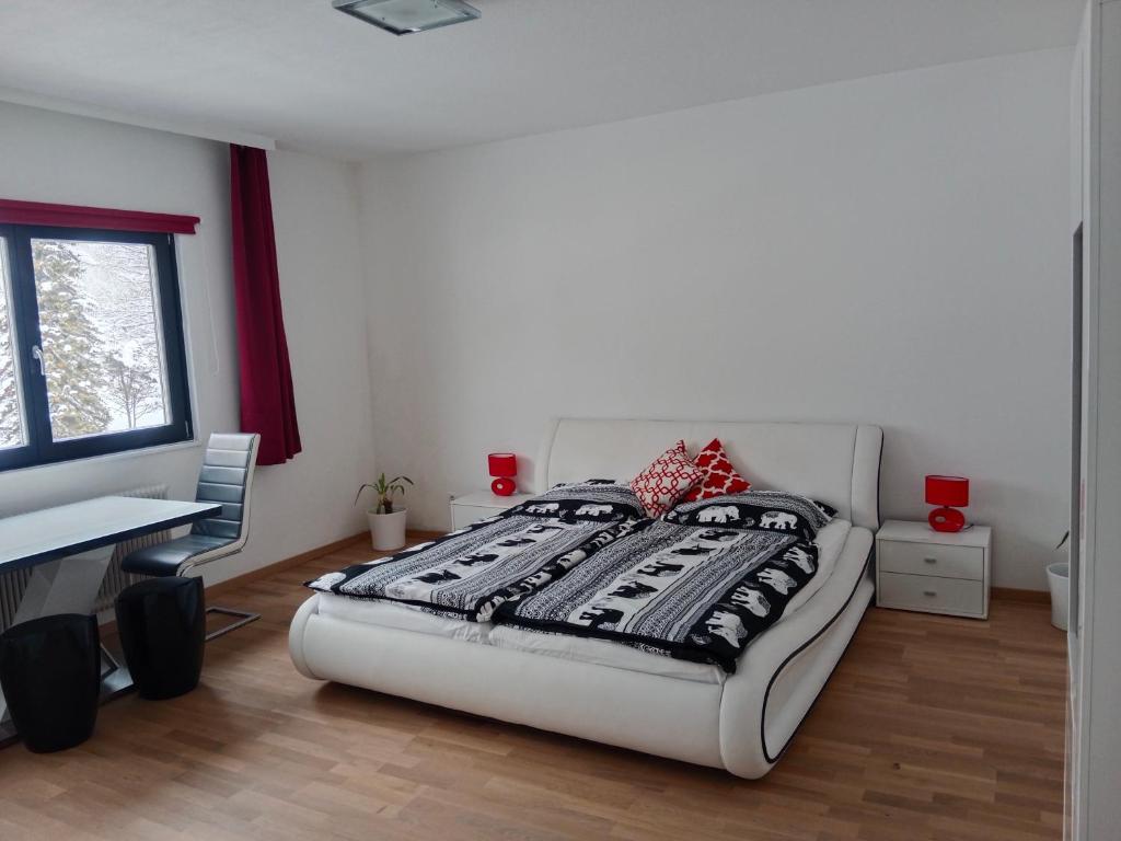 um quarto com uma cama, uma secretária e uma janela em Dachstein Apartments em Obertraun