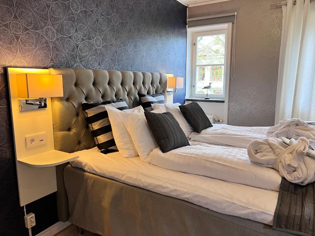 a large bed with a large headboard in a bedroom at Hotel Wictoria in Mariestad