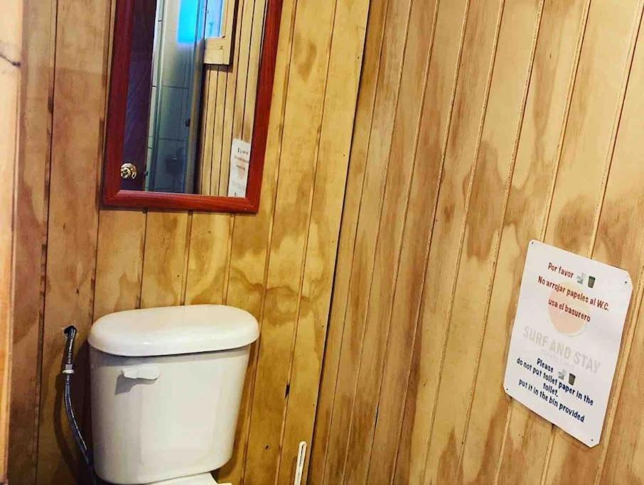uma casa de banho com WC numa parede de madeira em Surf and Stay Chile em Navidad