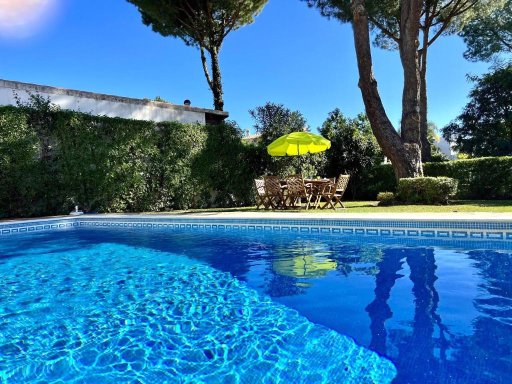 a swimming pool with a table and a yellow umbrella at Vilamoura Ocean Villa with Pool by Homing in Vilamoura