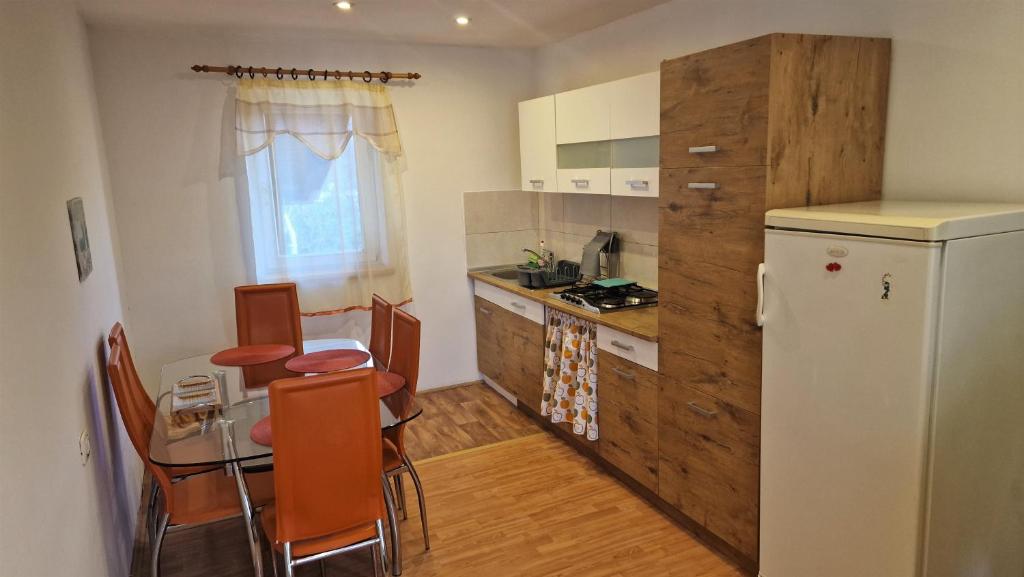 Il comprend une cuisine équipée d'une petite table et d'un réfrigérateur. dans l'établissement Simple 3-room apartment, à Kukuljanovo