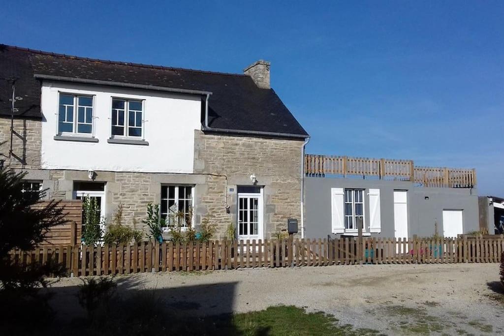 une grande maison blanche avec une clôture en bois dans l'établissement MAISON VACANCES VUE MER 500 m PLAGE, à Saint-Cast-le-Guildo