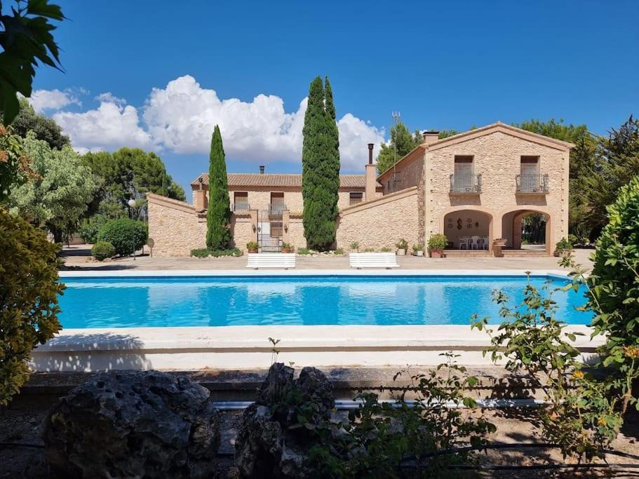 una finca con piscina frente a un edificio en El Rulón, gran villa rural con piscina privada, en Alicante