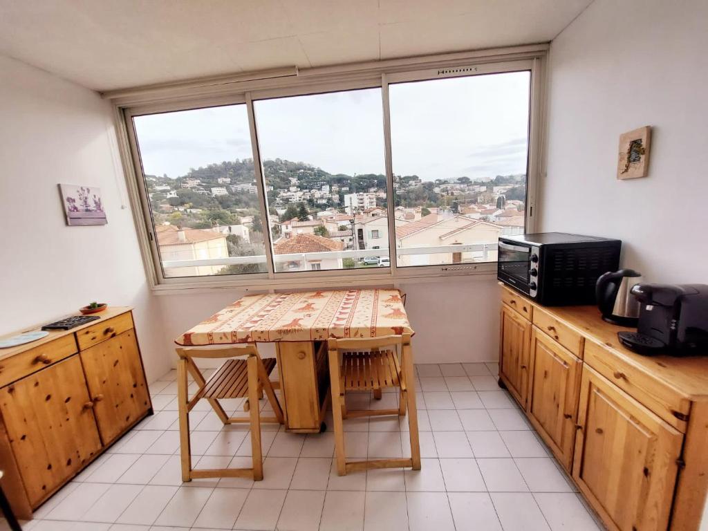 a kitchen with a table and a large window at Appt F2, Centre ville, 700m de la plage in Cannes