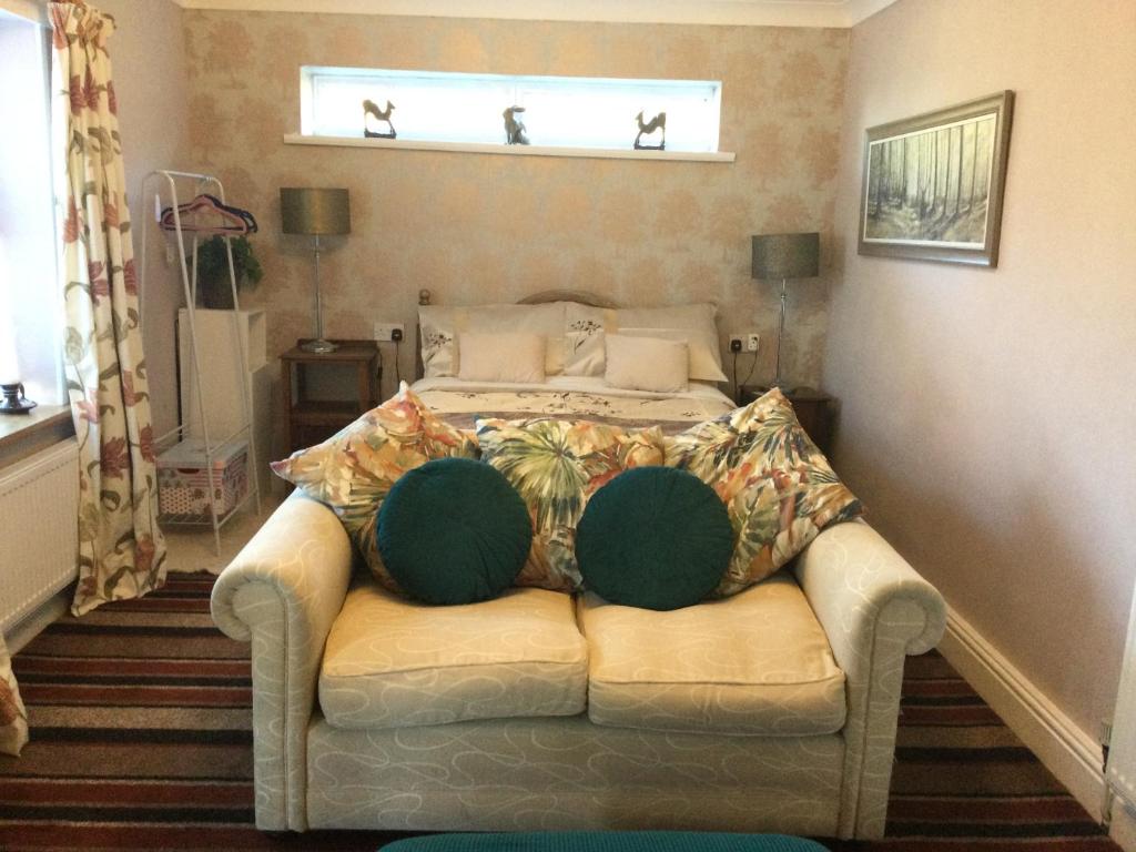a bedroom with a couch and a bed with a window at The Annex Rocket cottage in Sidestrand