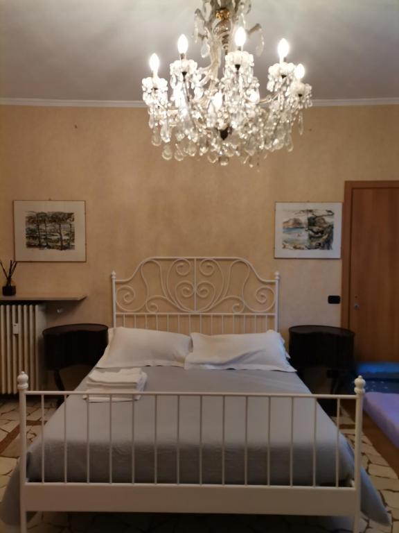 sypialnia z dużym łóżkiem i żyrandolem w obiekcie B&B Sotto le Mura w Bergamo