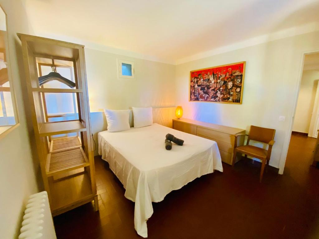 una camera da letto con un letto e una sedia di VIlla Saint Clair avec piscine a Sète