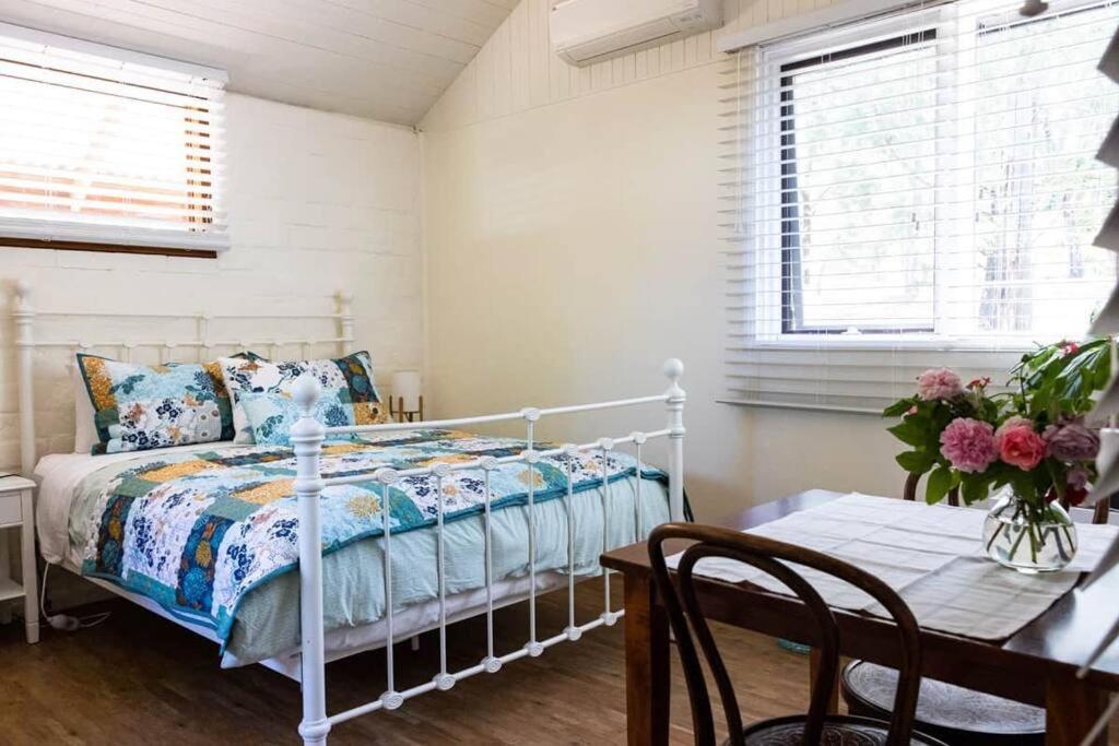 マルドンにあるMaldon Cosy Garden Cottage - Charming One Room Studioのベッドルーム(ベッド1台、テーブル付)