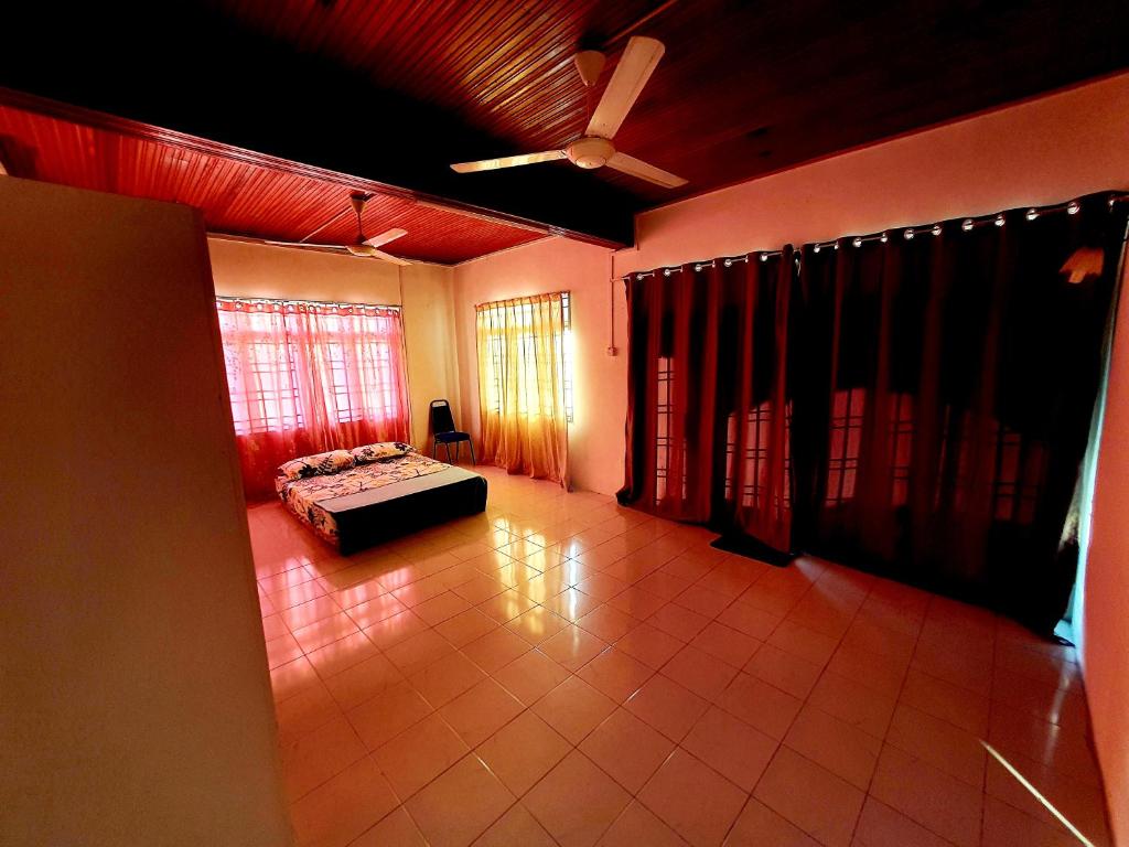 ein Wohnzimmer mit einem Bett und einem Deckenventilator in der Unterkunft Homestay Kuala Terengganu One Stop 2 in Kuala Terengganu