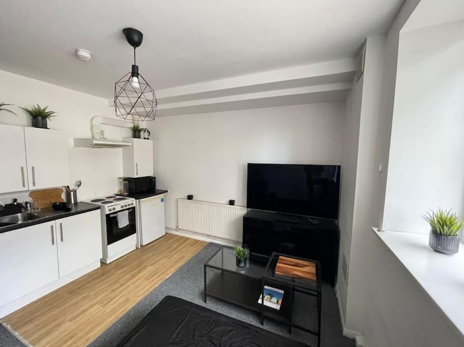 una cocina con armarios blancos y una cocina en blanco y negro en Comfortable modern (SMART) Studio in Walthamstow. en Londres