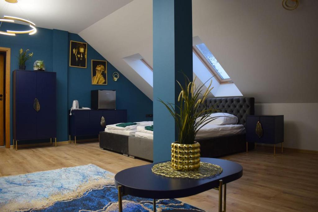 1 dormitorio con paredes azules, mesa y cama en Mały Książę, en Podzamcze