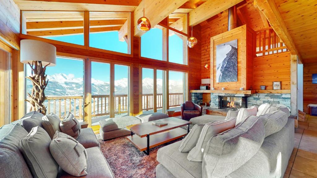 a living room with a couch and a fireplace at Egg SAUNA & LUXURY chalet 16 pers by Alpvision Résidences in Veysonnaz