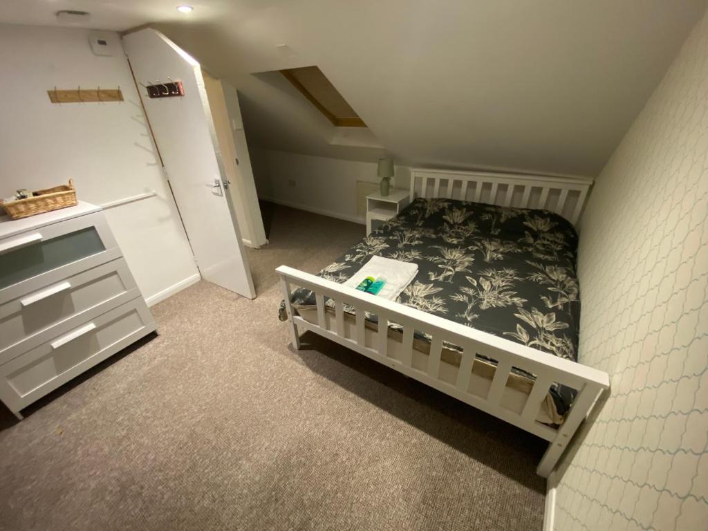 a small bedroom with a bed and a dresser at The Attic En-suite Room in Plymouth