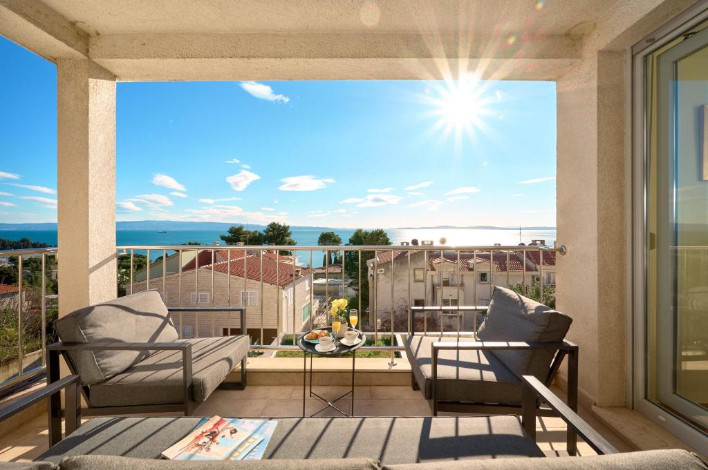 d'un balcon avec des chaises et une vue sur l'océan. dans l'établissement Sun Spalato Hills 7, à Split