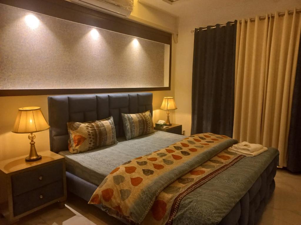 a bedroom with a bed with a large headboard at White House Executive - Guest House Islamabad in Rawalpindi