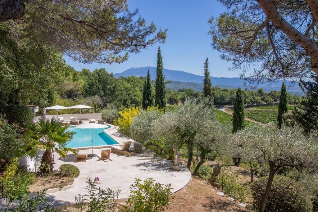 a swimming pool in a garden with trees at Villa Nymphée in Vaison-la-Romaine