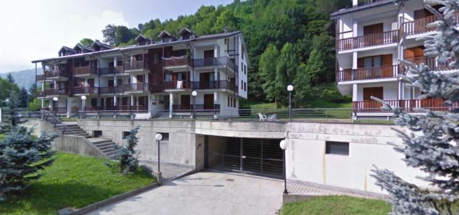 a large building with a parking lot in front of it at Les Deux Citrons in Limone Piemonte