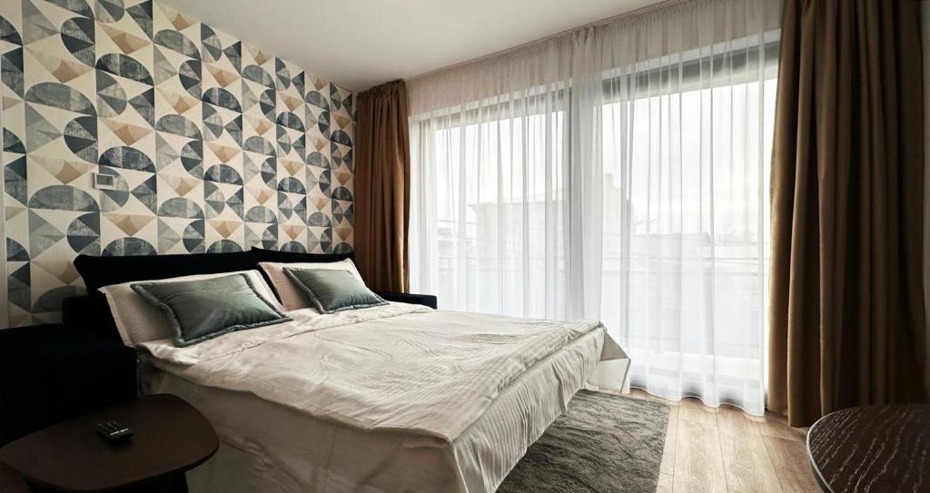 um quarto com uma cama e uma grande janela em Cubrio Apartments em Iaşi