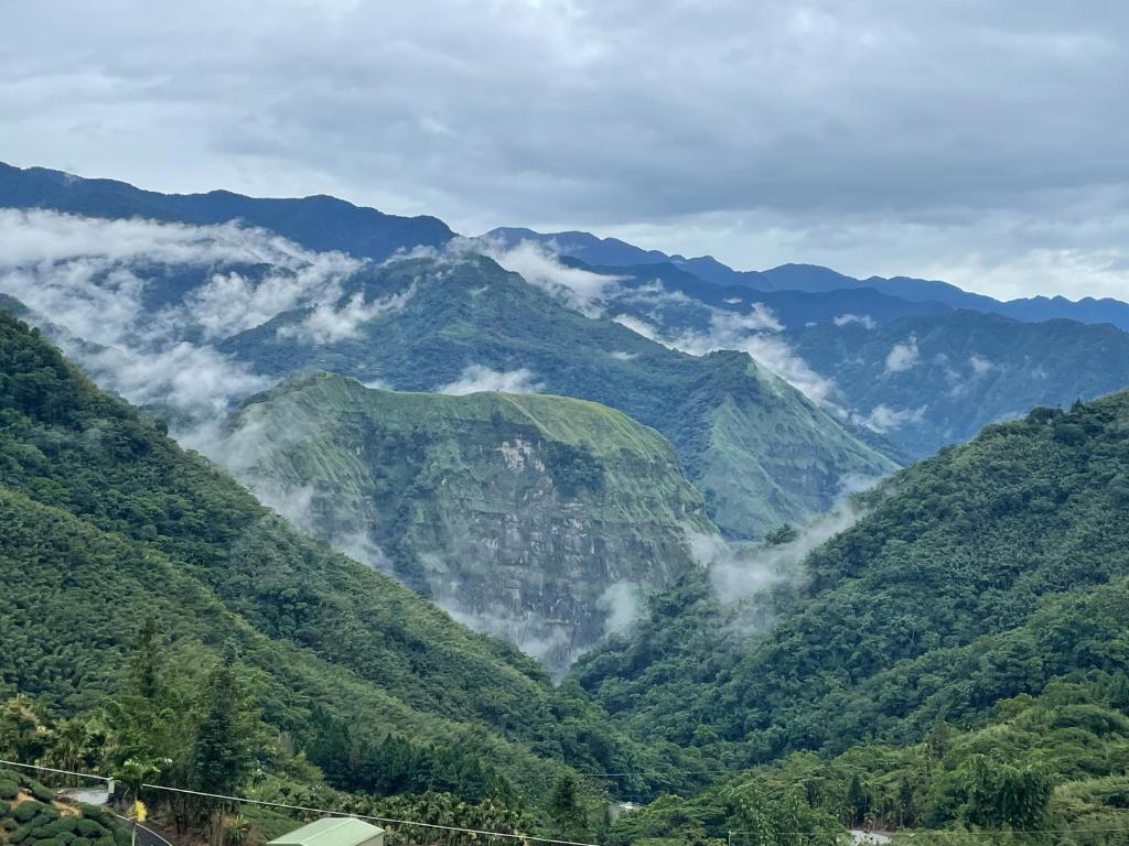 una vista de las montañas con nubes en el valle en 品味觀峰民宿, en Kung-t'ien-ts'un
