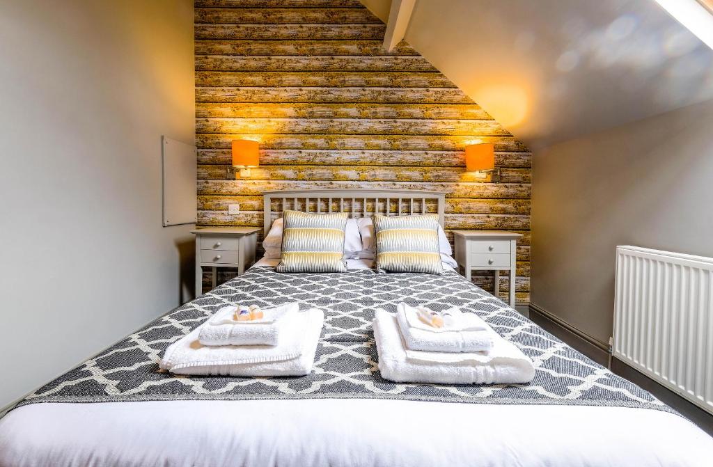 a bedroom with a large bed with towels on it at The Westleton Crown in Westleton