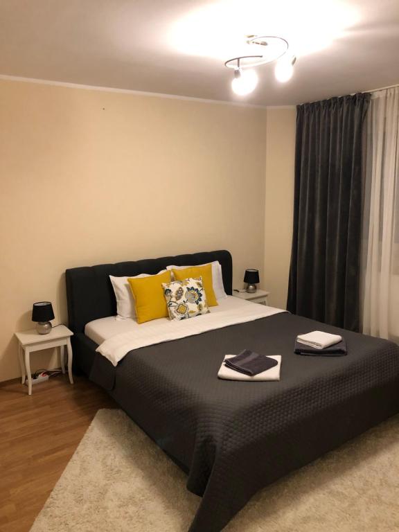 Un dormitorio con una cama grande con almohadas amarillas. en Maria, en Timisoara