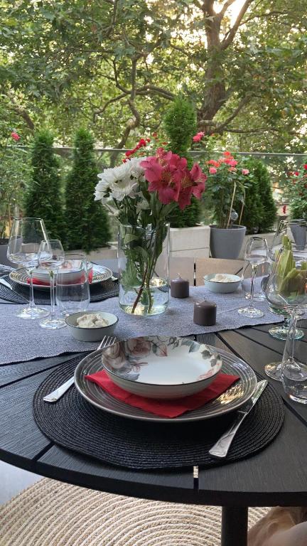 una mesa con platos y un jarrón de flores. en Sea Garden Apartment, en Varna