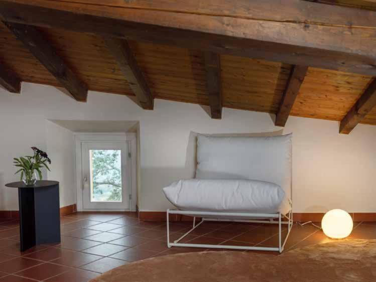 - un canapé dans une chambre dotée d'un plafond en bois dans l'établissement Borgo BiancoMatilde - Boutique Hotel, à Casina