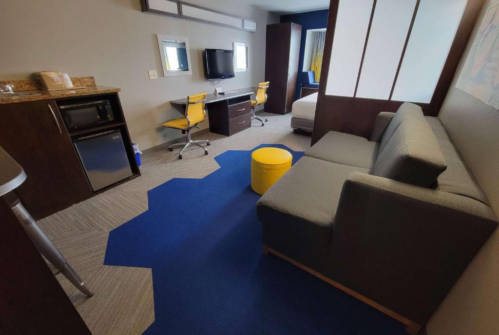 a living room with a couch and a blue carpet at Microtel Inn & Suites by Wyndham Bluffs in Council Bluffs