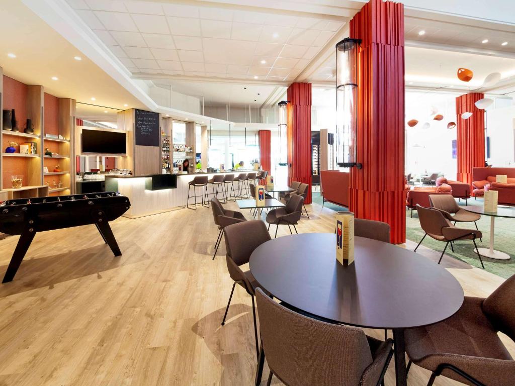 - un salon avec une table de billard et des chaises dans l'établissement Novotel Clermont-Ferrand, à Clermont-Ferrand