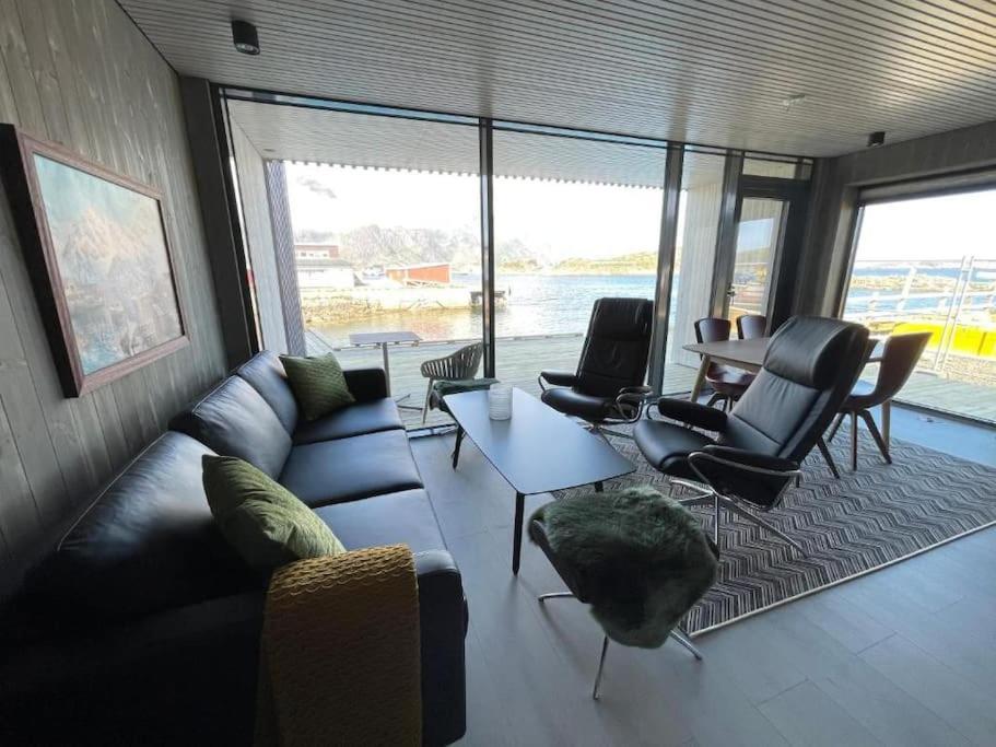 a living room with a couch and chairs and a table at Rorbuleilighet Lysøya 1H in Henningsvær