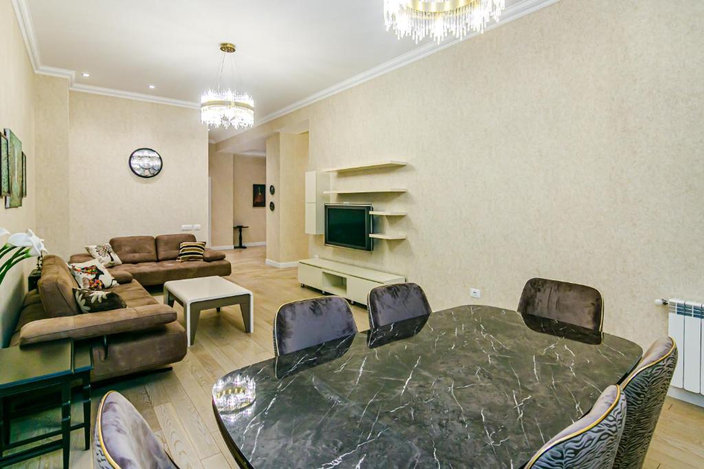a large living room with a table and a tv at Luxury House in Nizami Street in Baku