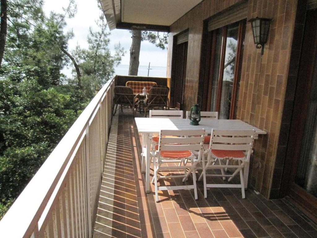 um pátio com uma mesa e cadeiras numa varanda em Breathtaking seaview in Grado - Beahost Rentals em Lido