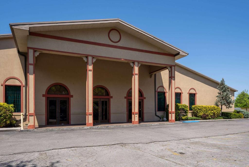 a building with columns and windows on a street at Days Inn By Wyndham Pigeon Forge South in Pigeon Forge