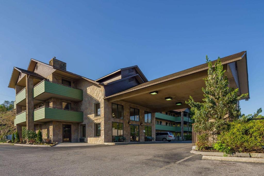 a large building with a tree in front of it at Days Inn By Wyndham Pigeon Forge South in Pigeon Forge