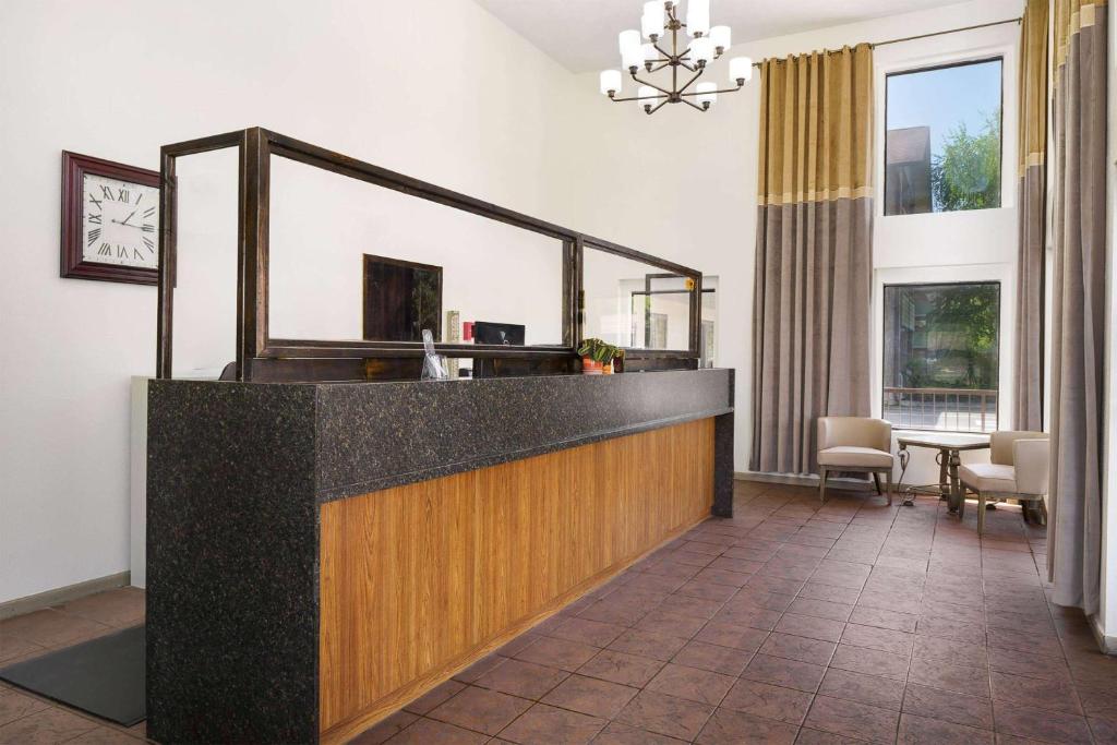 a lobby with a reception desk with a clock on the wall at Days Inn By Wyndham Pigeon Forge South in Pigeon Forge