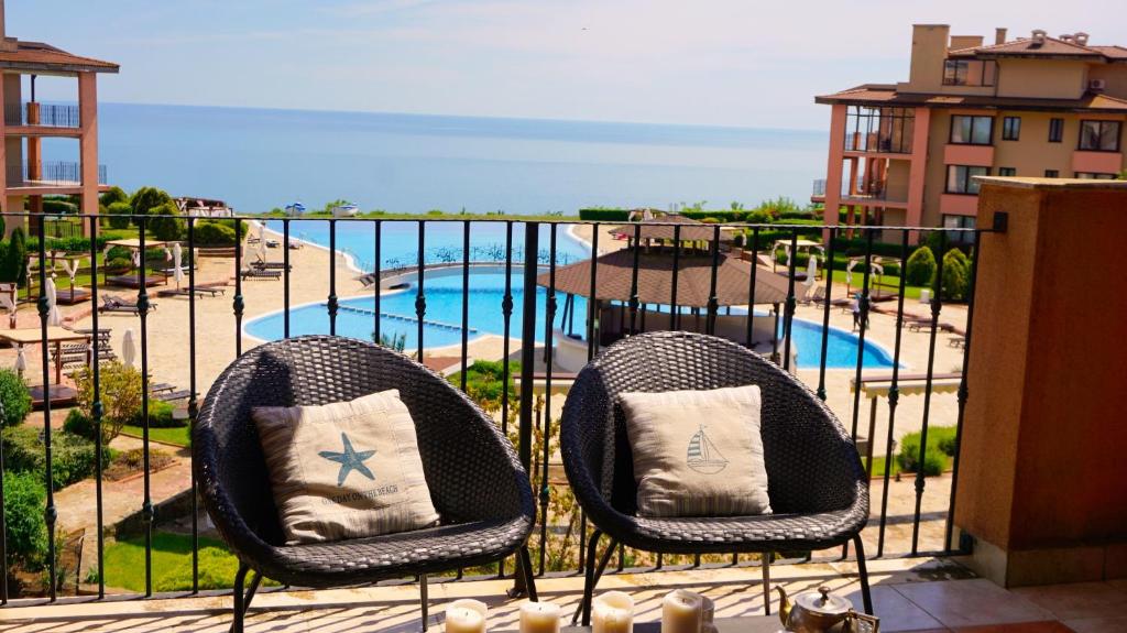 2 sedie su un balcone con vista sulla piscina di Apartment DECORA Sea View a Topola