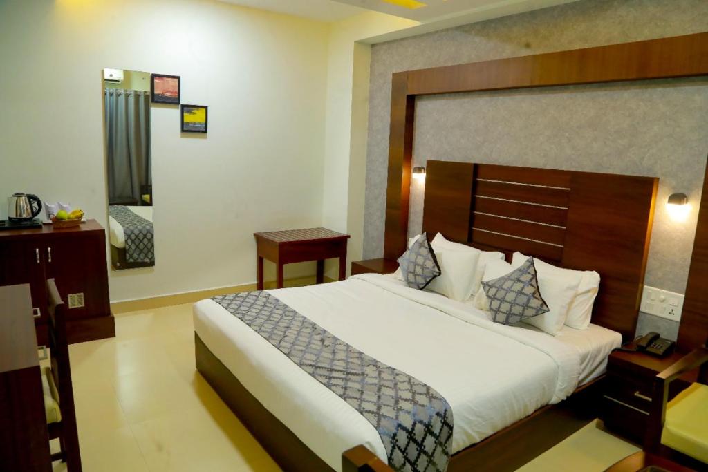 a bedroom with a large bed in a hotel room at CLUB 99 SUITES in Kakkanad