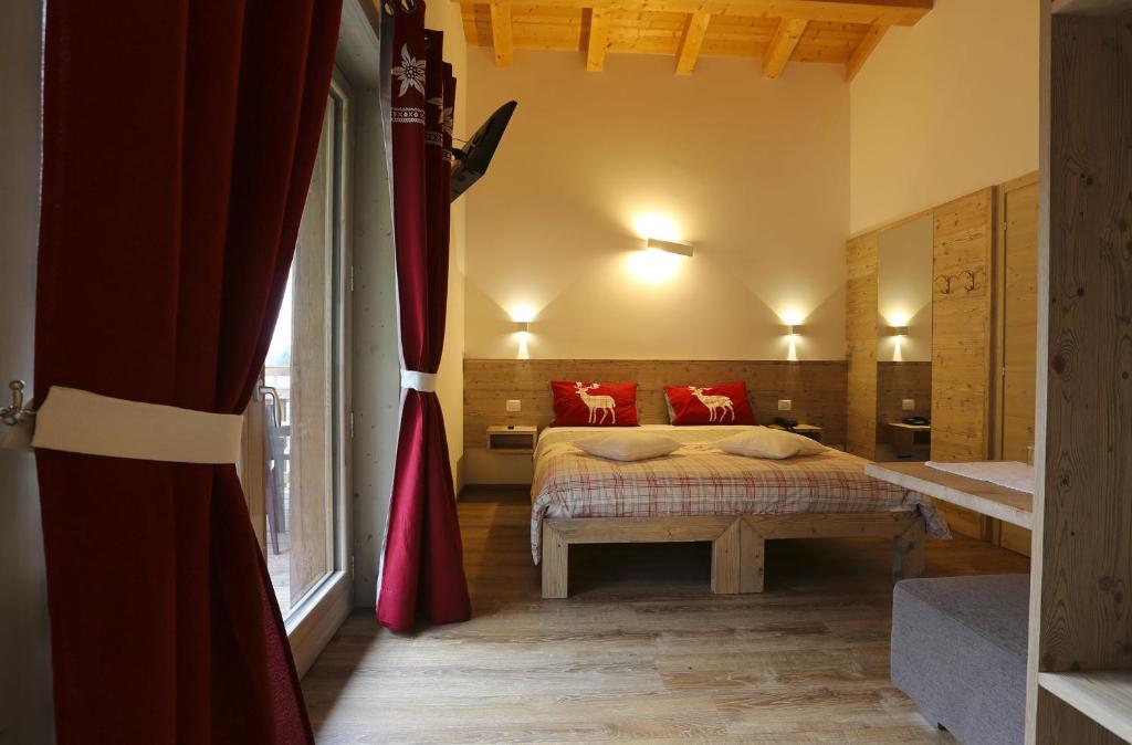 a bedroom with a bed and a window at Alpen Chalet in Schilpario