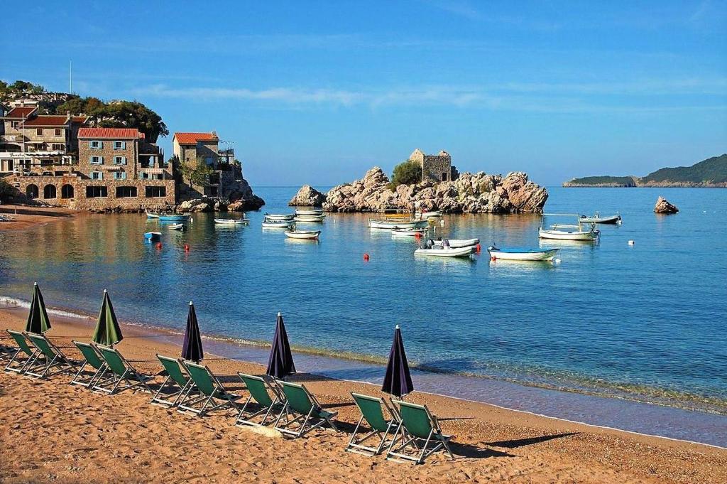 a group of lawn chairs and umbrellas on a beach at Status-M Apartments Przno in Pržno