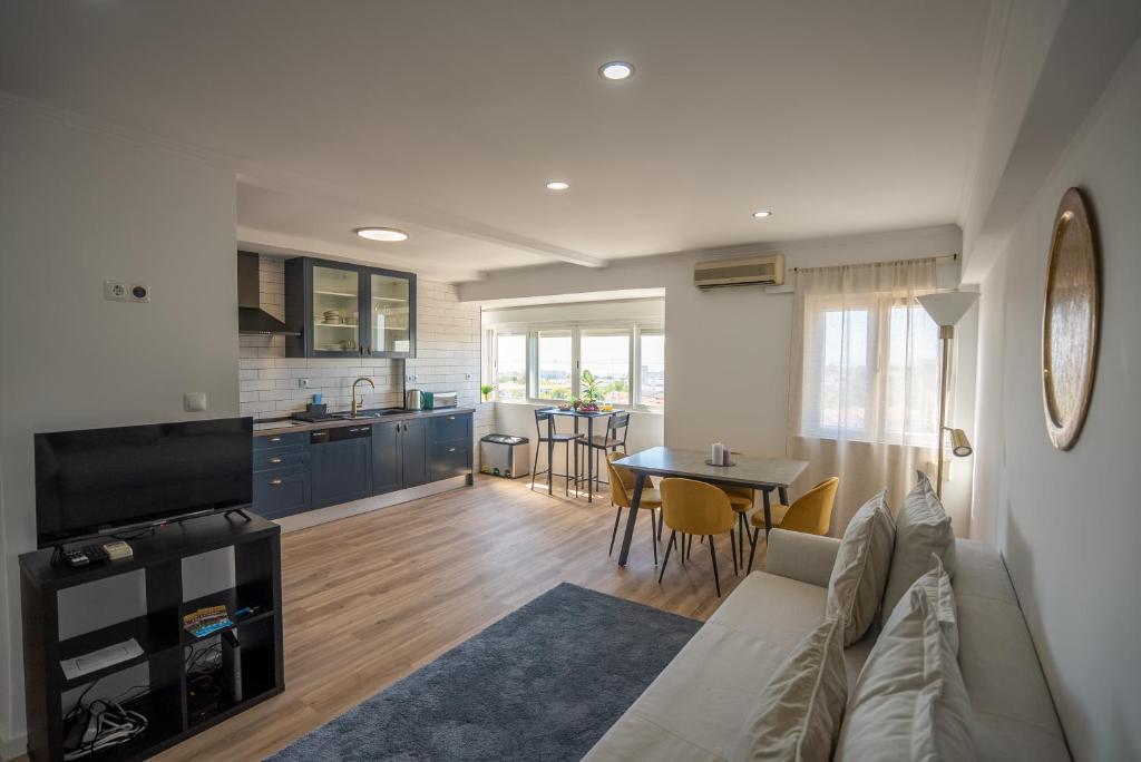a living room and kitchen with a couch and a table at Olivais Apartment River View in Lisbon